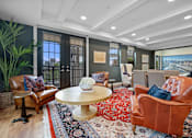 Thumbnail 47 of 64 - A living room with a brown leather chair and a round wooden table.