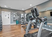 Thumbnail 25 of 64 - A gym with a treadmill, weights, and exercise equipment.