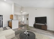 Thumbnail 28 of 54 - A modern living room with a black sofa and a television.