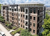 Thumbnail 61 of 64 - A large brick building with a balcony on the second floor.