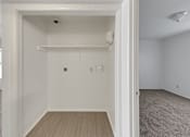 Thumbnail 8 of 27 - A white room with a doorway leading to another room.