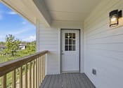 Thumbnail 21 of 27 - A white door is on the porch of a house.