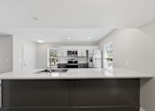 Thumbnail 2 of 27 - A modern kitchen with a large island in the middle.