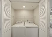 Thumbnail 7 of 27 - A small bathroom with two sinks and a washer and dryer.