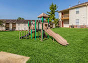 Thumbnail 24 of 27 - A playground with a green slide and a brown slide.