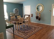 Thumbnail 25 of 27 - A dining room with a table and chairs.