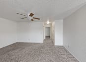 Thumbnail 9 of 27 - A room with a ceiling fan and carpeted floor.