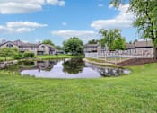 Thumbnail 31 of 38 - A pond in front of a row of houses.