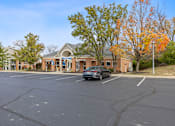 Thumbnail 39 of 57 - a car parked in a parking lot in front of a building at Indian Lookout Apartments, West Carrollton