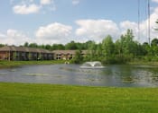 Thumbnail 15 of 21 - A pond with a fountain in the middle of it.