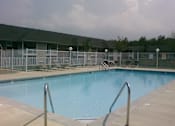 Thumbnail 12 of 21 - A swimming pool surrounded by a metal fence.