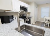 Thumbnail 2 of 40 - A kitchen with a sink and a microwave.