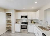 Thumbnail 1 of 40 - A kitchen with white cabinets and a stainless steel oven.