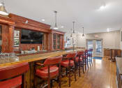 Thumbnail 40 of 54 - a bar with red chairs in a room with a television at Indian Creek Apartments*, Ohio