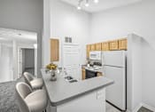 Thumbnail 7 of 54 - A kitchen with a white refrigerator and a grey counter top.