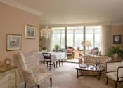 Thumbnail 3 of 25 - A living room with a chair, a sofa, a coffee table, and a chandelier.