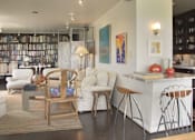 Thumbnail 1 of 25 - A modern living room with a kitchen area in the background.