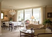 Thumbnail 4 of 25 - A well-lit living room with a dining table and chairs.
