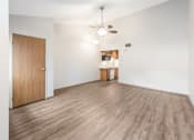 Thumbnail 24 of 32 - an empty living room and kitchen with wood flooring and a ceiling fan at Parkside at Maple Canyon Apartments, Columbus, 43229