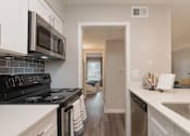 Thumbnail 15 of 33 - A kitchen with black and white appliances and a white counter at A62 Apartments, Indianapolis, IN 46220