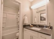 Thumbnail 19 of 33 - A bathroom with a white sink and a mirror above it at A62 Apartments, Indiana