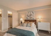 Thumbnail 12 of 33 - A bedroom with a bed, nightstand, and two lamps at A62 Apartments, Indiana