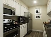 Thumbnail 2 of 33 - A kitchen with black countertops and white cabinets at A62 Apartments, Indiana 46220