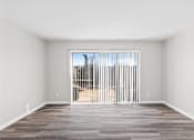 Thumbnail 12 of 32 - A room with a large window and a wooden floor.