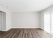 Thumbnail 16 of 32 - A room with wooden flooring and white walls.
