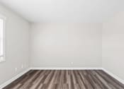Thumbnail 28 of 32 - A room with wooden flooring and white walls.