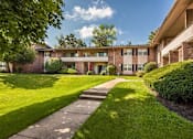 Thumbnail 29 of 32 - A residential building with a green lawn in front.