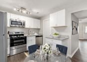 Thumbnail 8 of 32 - A modern kitchen with a dining table set for two.