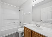 Thumbnail 23 of 54 - A white bathroom with a toilet, sink, and bathtub.