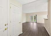 Thumbnail 33 of 54 - A room with a white door and a wooden floor.