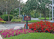 Thumbnail 16 of 25 - A sign that says entrance in front of a field of flowers.