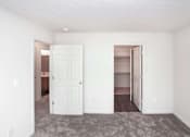 Thumbnail 4 of 21 - A room with a white door and a carpeted floor.
