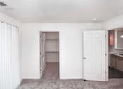 Thumbnail 5 of 21 - A white room with a doorway leading to another room.