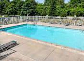 Thumbnail 11 of 21 - A large outdoor swimming pool surrounded by a metal fence.