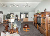 Thumbnail 8 of 21 - A living room with a grey couch and wooden furniture.