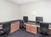 Thumbnail 7 of 21 - A small office with two computers and two chairs.