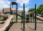 Thumbnail 26 of 40 - A playground with a slide and a climbing frame.