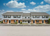 Thumbnail 35 of 40 - A two-story building with a parking lot in front.