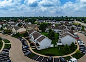Thumbnail 38 of 40 - A residential area with houses and cars parked in a lot.