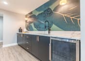 Thumbnail 51 of 65 - a kitchen with black cabinets and a sink and a painting on the wall
