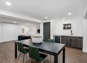 Thumbnail 33 of 65 - a dining area with a table and chairs and a kitchen in the background