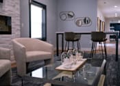 Thumbnail 54 of 80 - a living room with a glass coffee table and chairs and a kitchen with a bar at Ten31, Dayton, OH