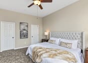Thumbnail 11 of 44 - A bedroom with a large bed and a ceiling fan.