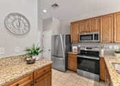 Thumbnail 2 of 44 - A kitchen with granite countertops and wooden cabinets.