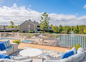 Thumbnail 26 of 46 - A house with a pool and a deck with a white table and chairs.