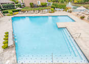 Thumbnail 23 of 46 - A large blue swimming pool with a diving board.